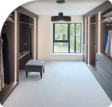 Walk-in fitted dressing room with hanging rails, drawers and a window seat